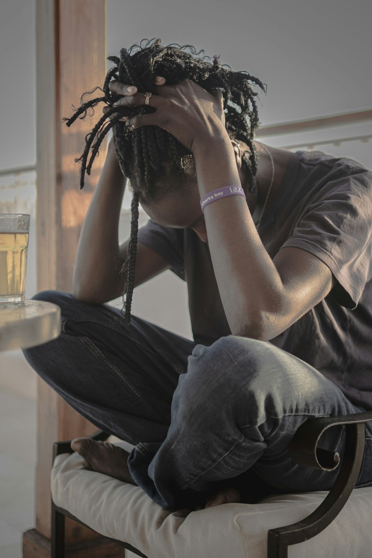 A man sitting on a chair with his head in his hands